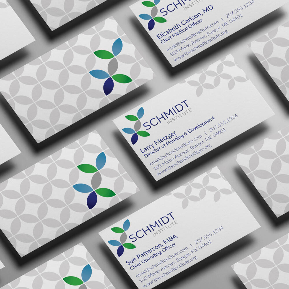 A mockup of business cards with the Schmidt Institute branding on front and back, featuring a geometric repeating pattern