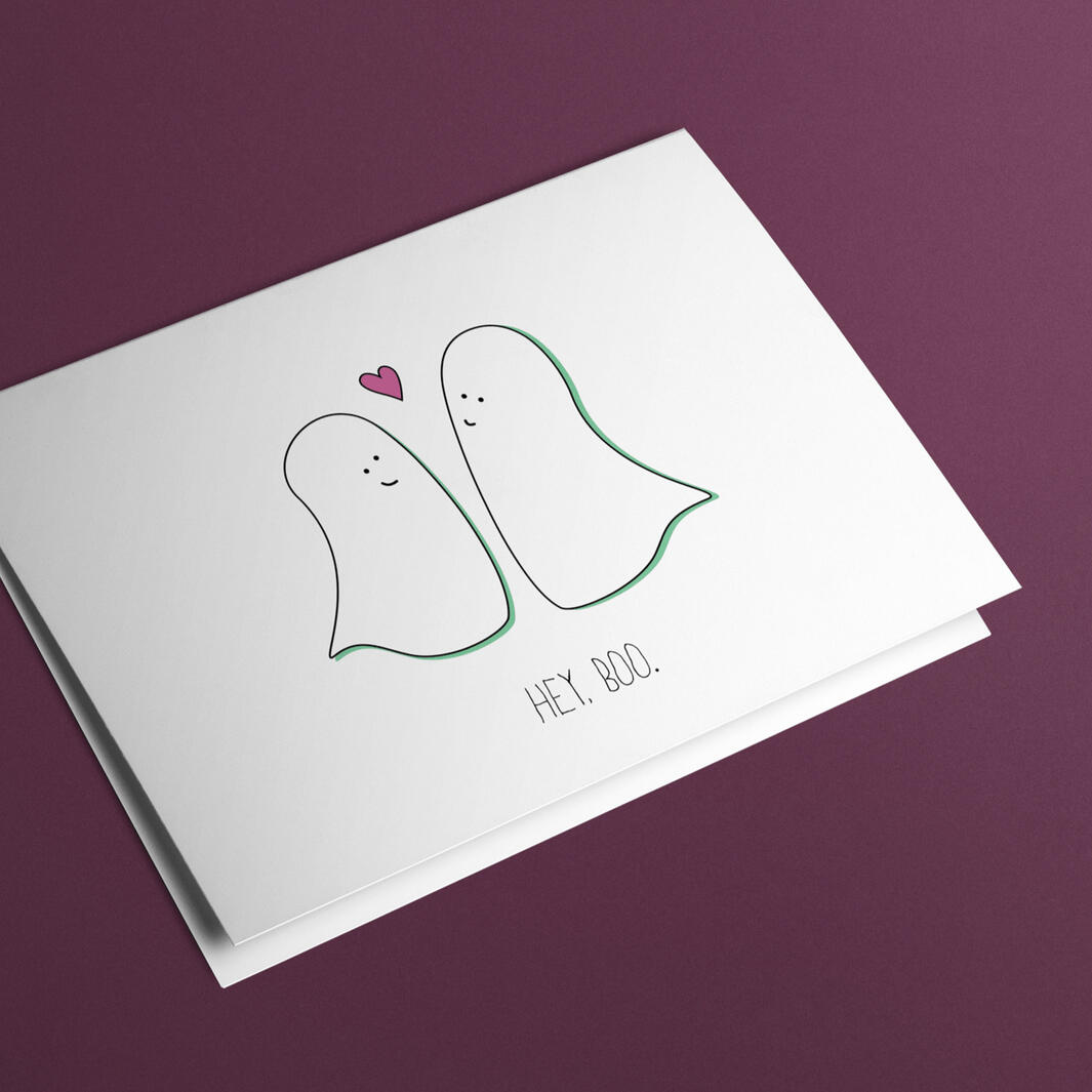 Illustrated greeting card with two ghosts smiling at each other with a small heart in between them. Below, words read: "Hey Boo."